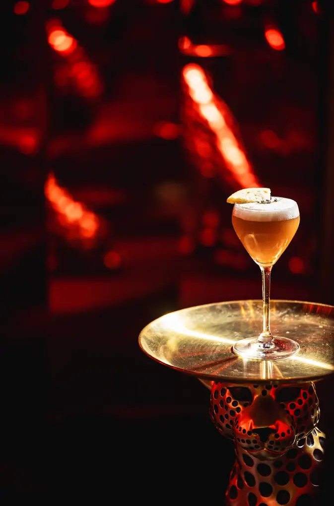 A cocktail served on a gold leopard stand