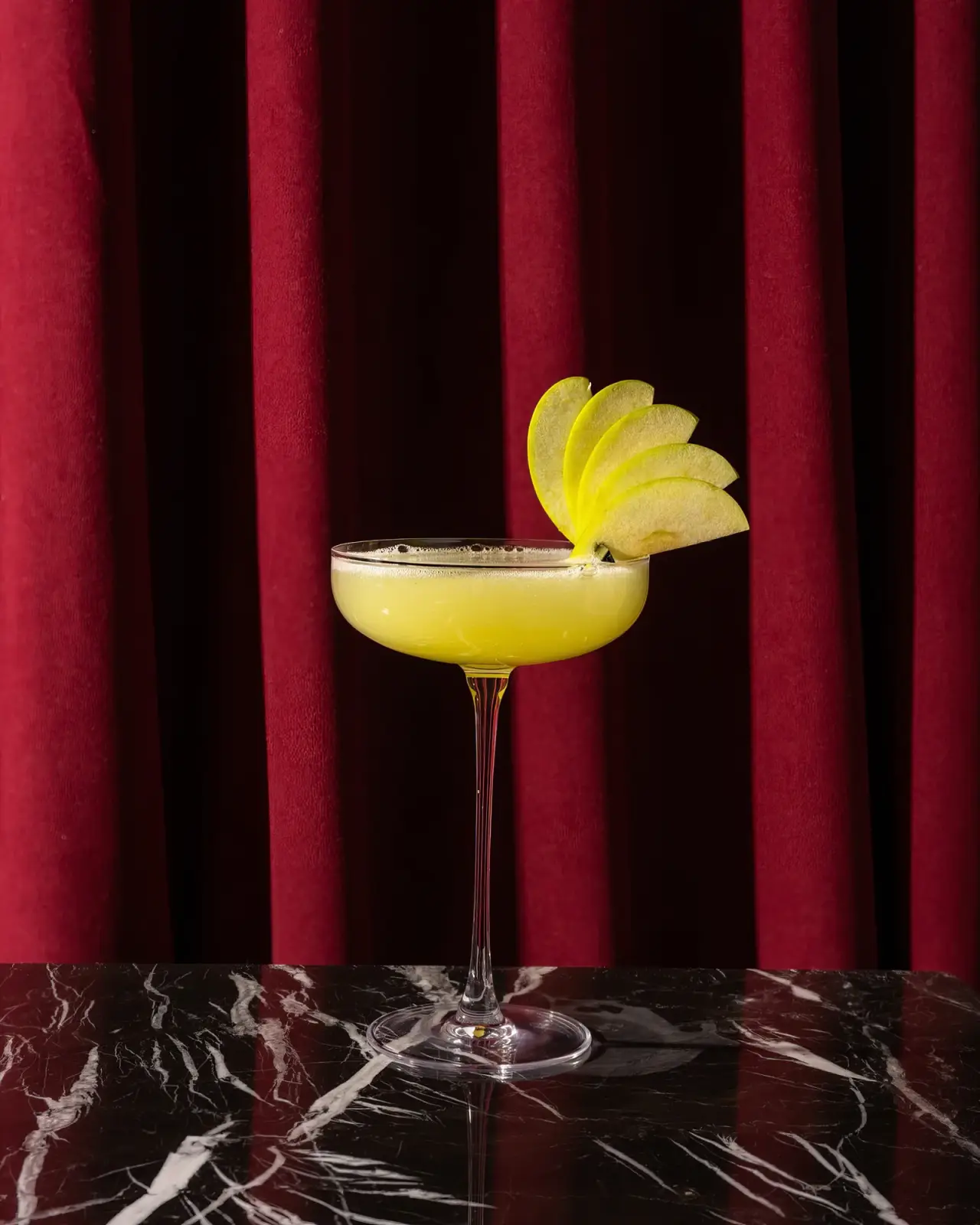 A cocktail in front of the red curtain