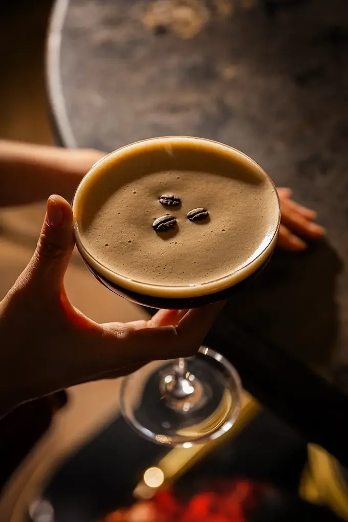 An espresso martini topped with coffee beans