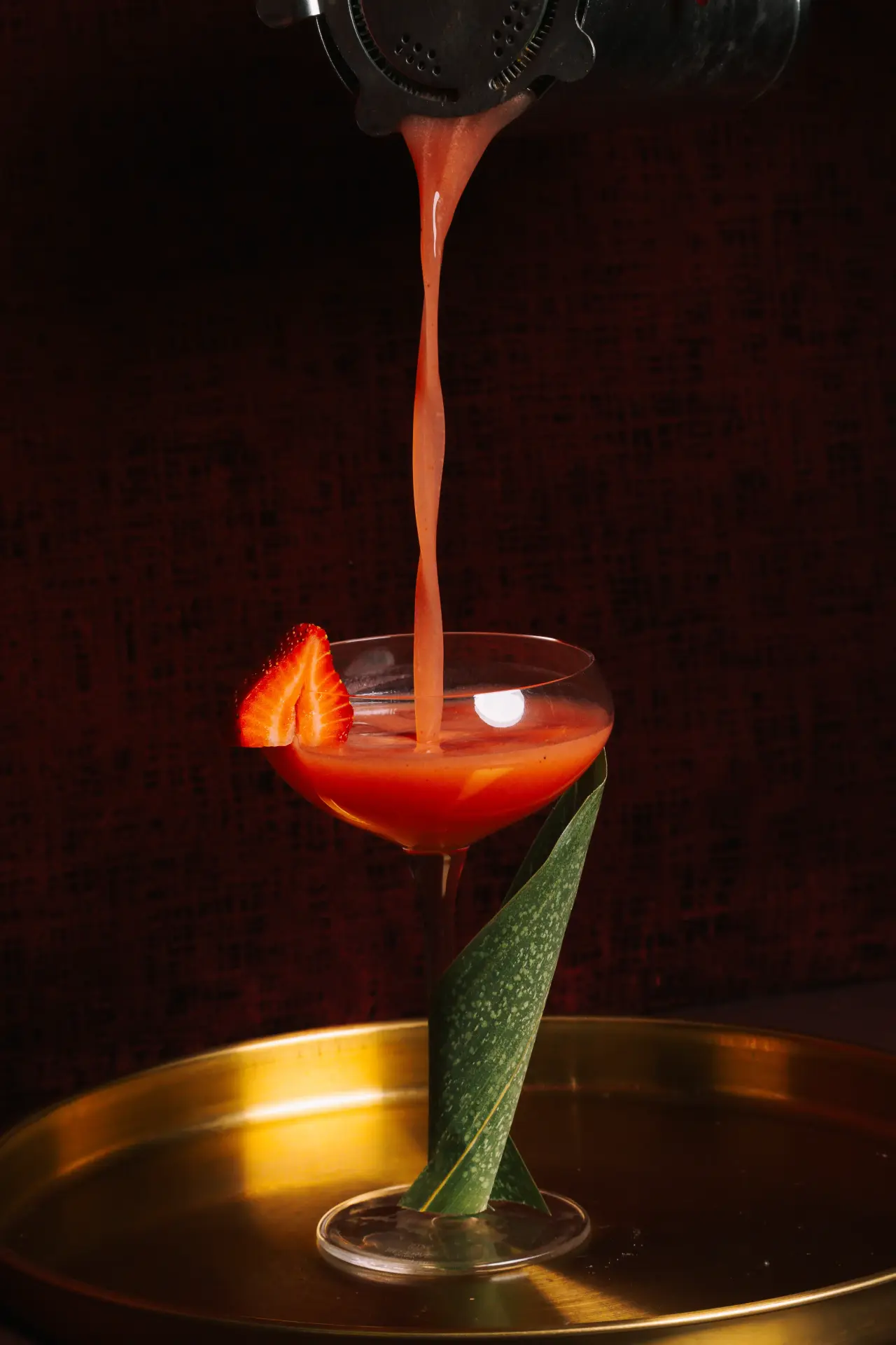 A strawberry martini being poured